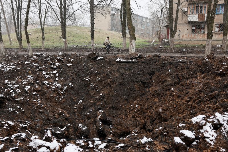 &copy; Reuters. شخص يقود دراجة هوائية بالقرب من حفرة ناتجة عن قصف روسي في شرق دونيتسك بأوكرانيا يوم 30 مارس آذار 2023. تصوير: فيوليتا سانتوس مورا – رويترز.