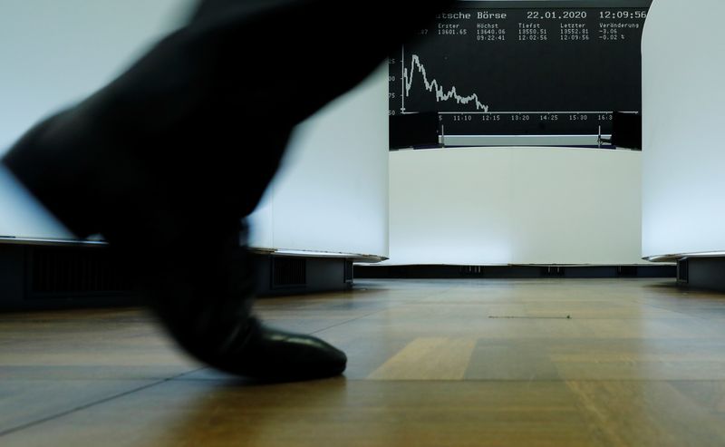 &copy; Reuters. Photo d'un trader qui passe devant le graphique DAX de l'indice boursier allemand à la bourse de Francfort. /Photo prise le 22 janvier 2020 à Francfort, Allemagne/REUTERS/Ralph Orlowski