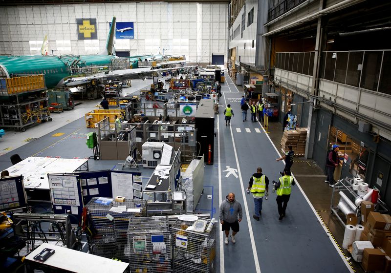 © Reuters. FILE PHOTO: Workers walk by a 737 Max aircraft on the production line at the Boeing factory in Renton, Washington, U.S., March 27, 2019.  REUTERS/Lindsey Wasson/File Photo