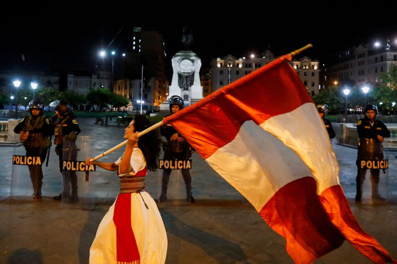 &copy; Reuters. Forças de segurança em guarda enquanto manifestante agita bandeira do Peru em protesto contra a presidente Dina Boluarte em Lima
12/01/2023
REUTERS/Alessandro Cinque