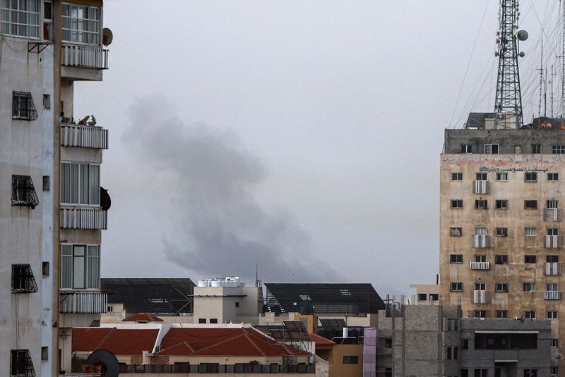 &copy; Reuters. أعمدة الدخان ترتفع من بين المباني في غزة على إثر ضربات جوية إسرائيلية في القطاع يوم الأربعاء. تصوير: محمد سالم - رويترز 