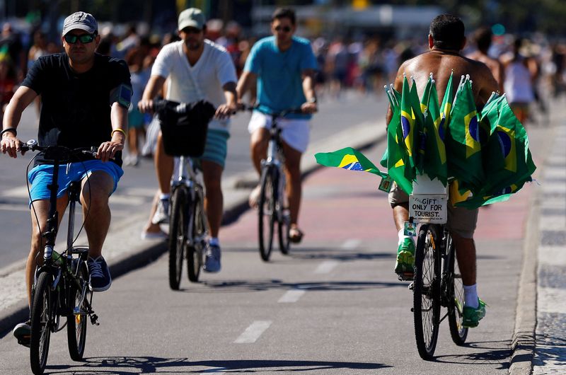 &copy; Reuters. FILE PHOTO: A man rides his bike carrying Brazilian national flags in Copacabana beach in Rio de Janeiro July 6, 2014. REUTERS/Ricardo Moraes/File Photo