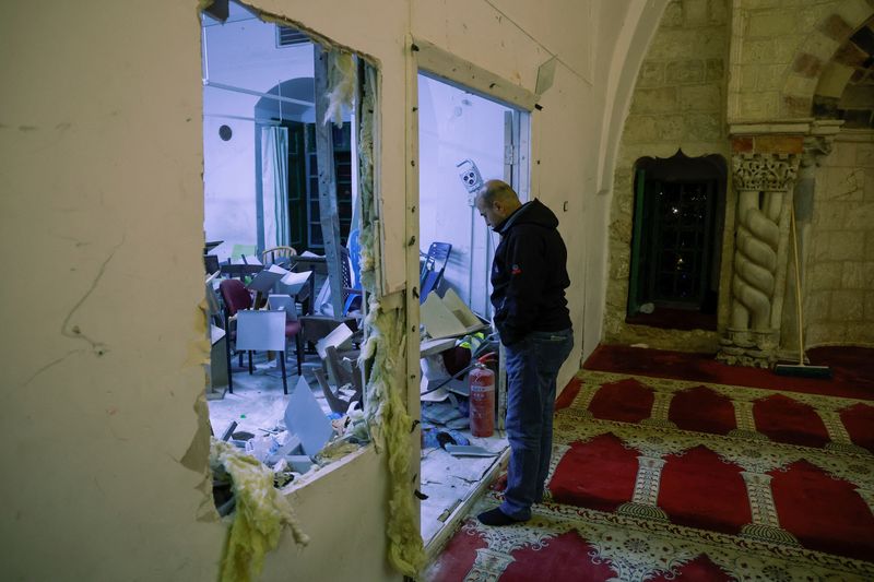 © Reuters. رجل ينظر إلى آثار اقتحام القوات الإسرائيلية للمسجد الأقصى خلال اشتباكات وقعت مع المصلين في البلدة القديمة بالقدس. تصوير : عمار عوض - رويترز . 