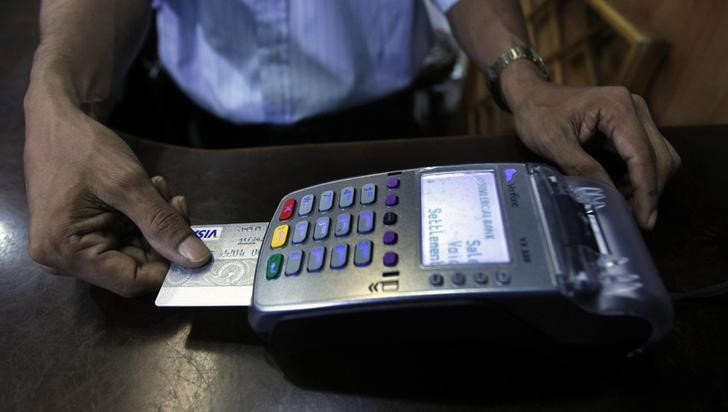 &copy; Reuters. Un venditore inserisce una carta di credito in un pos, a Colombo, Sri Lanka, 11 giugno 2013.   REUTERS/Dinuka Liyanawatte (SRI LANKA - Tags: BUSINESS)