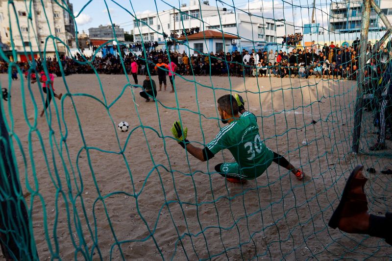 &copy; Reuters. فلسطينيون يلعبون كرة القدم في أثناء شهر رمضان المبارك في رفح بجنوب قطاع غزة في 31 مارس آذار 2023. تصوير: إبراهيم أبو مصطفى - رويترز.