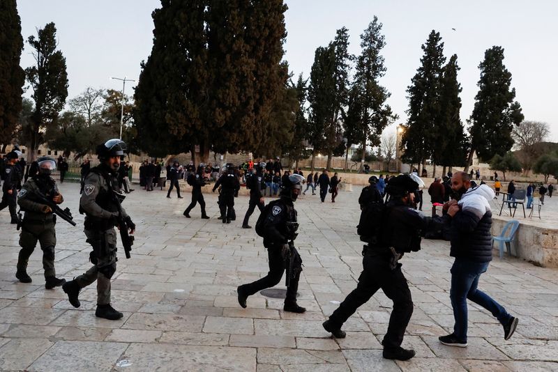 © Reuters. أحد عناصر الشرطة الإسرائيلية يعتقل فلسطينيا داخل المسجد الأقصى أثناء اشتباكات بين الجانبين يوم الأربعاء. تصوير : عمار عوض - رويترز .   