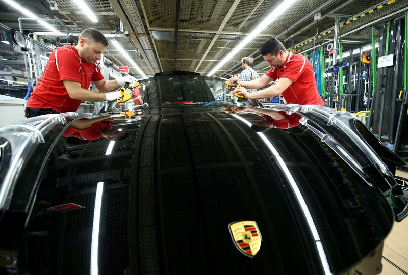 &copy; Reuters. موظفو شركة بورش الألمانية لصناعة السيارات يقومون بتثبيت الزجاج الأمامي لسيارة في مصنع الشركة بشتوتجارت. صورة من أرشيف رويترز.