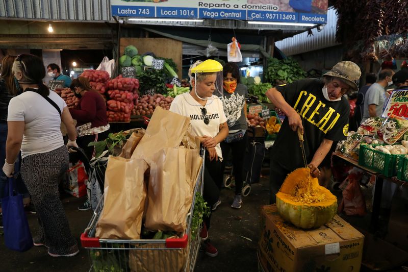 © Reuters. FILE PHOTO: A woman wearing a preventive face shield attends the market, following the outbreak of coronavirus disease (COVID-19) in Santiago, Chile April 7, 2020. REUTERS/Ivan Alvarado