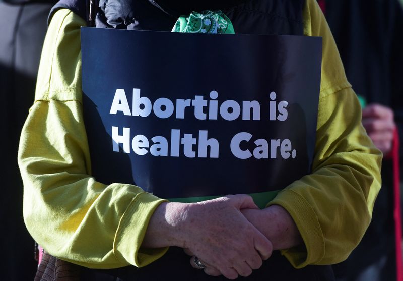 &copy; Reuters. Kathy Thomas holds a “abortion is healthcare” sign during the Women's March protest outside of the Federal Courthouse against U.S. District Judge Matthew Kacsmaryk as he hears a motion by anti-abortion groups led by Alliance for Hippocratic Medicine t