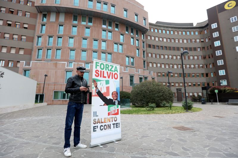 © Reuters. A supporter of former Italian Prime Minister Silvio Berlusconi stands near the 'San Raffaele' hospital, where former Italian Prime Minister is hospitalised, in Milan, Italy, April 7, 2023. REUTERS/Claudia Greco