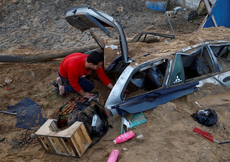 © Reuters. فلسطيني يتفقد الدمار الذي لحق بسيارته بفعل ضربات جوية إسرائيلية على قطاع غزة يوم الجمعة. تصوير: محمد سالم - رويترز.