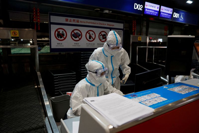 &copy; Reuters. FOTO DE ARCHIVO: El personal de una aerolínea lleva equipo de protección individual (EPI) para protegerse del COVID-19 mientras trabajan en el Aeropuerto Internacional Pekín Capital en Pekín, China. 13 de marzo, 2022. REUTERS/Soe Zeya Tun
