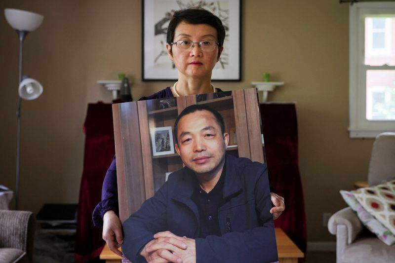 &copy; Reuters. Sophie Luo Shengchun, the wife of jailed Chinese human rights lawyer, Ding Jiaxi, poses with a photo of him at her home in Alfred, New York, U.S., July 28, 2022. REUTERS/Brendan McDermid