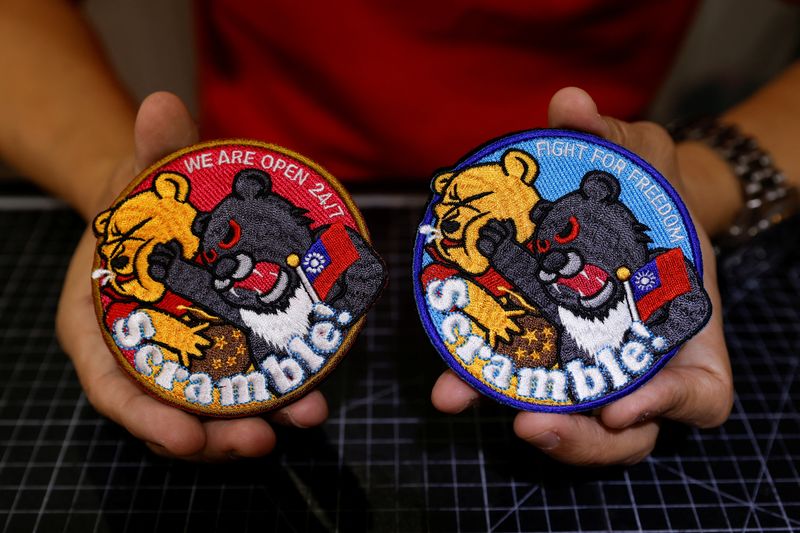 &copy; Reuters. Alec Hsu shows to the camera patches depicting a Formosan black bear holding Taiwan’s flag and punching Winnie the Pooh at his store in Taoyuan, Taiwan April 10, 2023. REUTERS/Carlos Garcia Rawlins