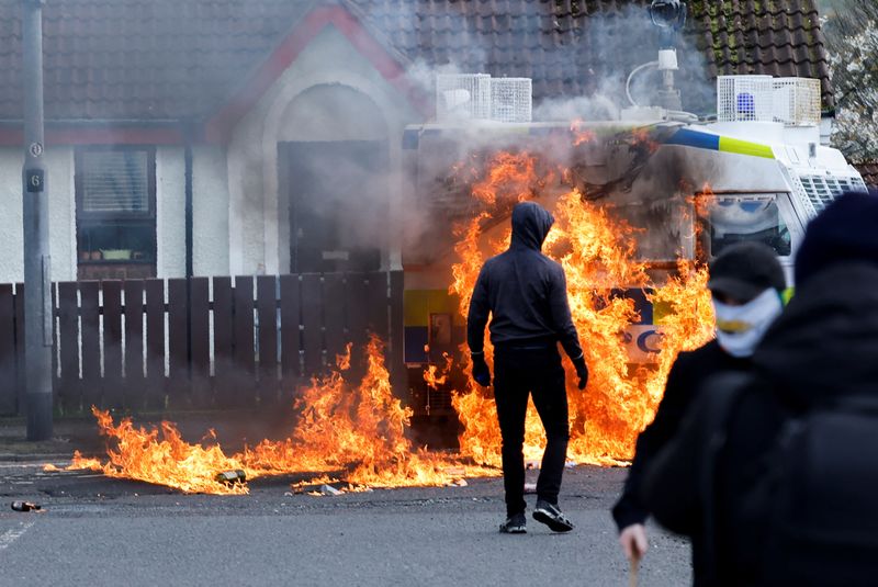 &copy; Reuters. أعضاء من القوميين الأيرلنديين يقفون بالقرب من سيارة شرطة محترقة بينما ينظم القوميون مسيرة مناهضة لاتفاق السلام في ذكراه الخامسة والعشرين، 