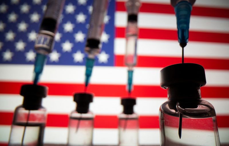 &copy; Reuters. Vials and syringes are seen in front of displayed U.S. flag in this illustration photo taken March 16, 2021.  REUTERS/Dado Ruvic/Illustration