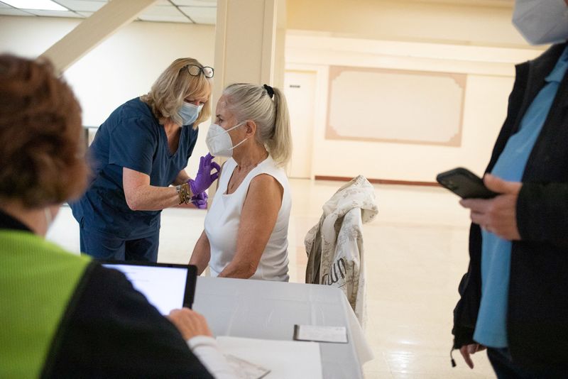 &copy; Reuters. سيدة في الخمسين من العمر تتلقى جرعة ثانية من لقاح مضاد لفيروس كوفيد-19 بولاية ميشيجان الأمريكية في صورة من أرشيف رويترز .    
