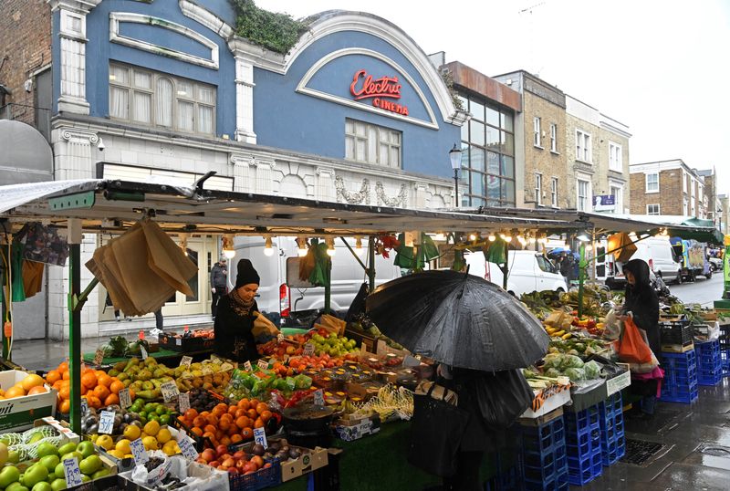 &copy; Reuters. FILE PHOTO: Customers shop at a fruit and vegetable stall at Portobello Road in London, Britain, March 31, 2023. REUTERS/Toby Melville