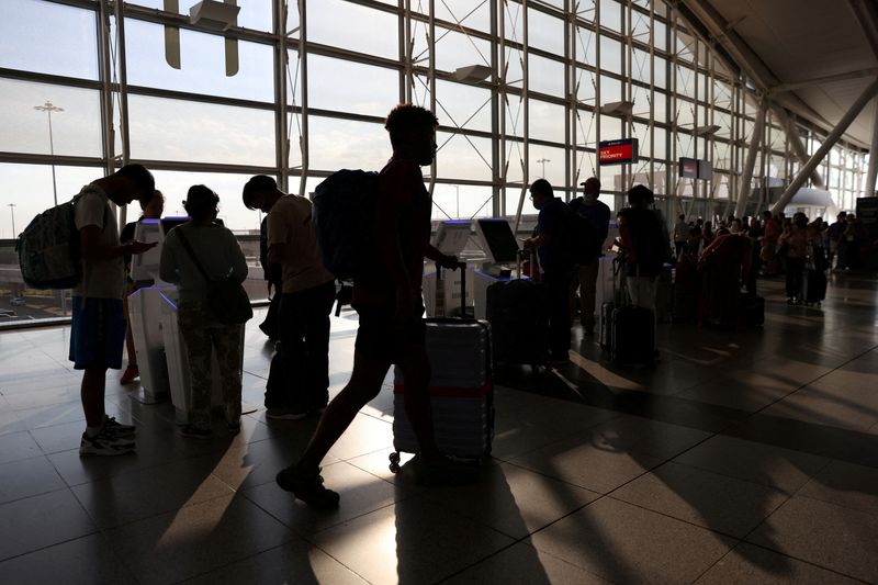 &copy; Reuters. FILE PHOTO: Passengers use self check-in machines as they travel from John F. Kennedy International Airport, in Queens, New York City, U.S., July 2, 2022. REUTERS/Andrew Kelly