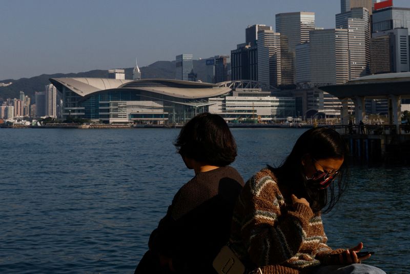 &copy; Reuters. FOTO DE ARCHIVO: Varias personas sentadas junto al mar en Hong Kong, China, el 28 de diciembre de 2022. REUTERS/Tyrone Siu