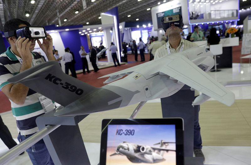 &copy; Reuters. FILE PHOTO: Men look at KC-390 aircraft as they visit the Embraer's exhibition stand during LAAD, the biggest military industry expo in Latin America in Rio de Janeiro, Brazil April 2, 2019. REUTERS/Ricardo Moraes/File Photo