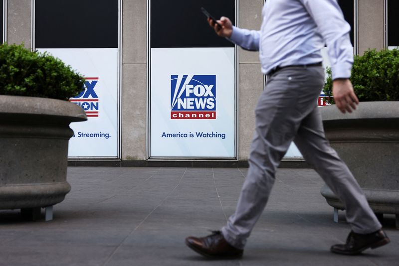 © Reuters. A person walks by Fox News signage posted on the News Corporation building in New York City, U.S. April 12, 2023 REUTERS/Andrew Kelly