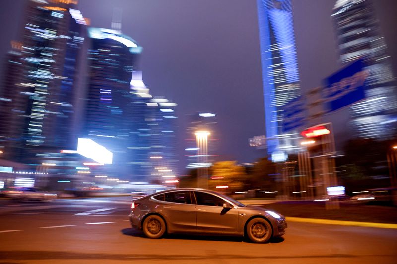 © Reuters. FILE PHOTO: A Tesla electric vehicle (EV) drives past a crossing in Shanghai, China March 9, 2021.  To match Special Report TESLA-PRIVACY/CAMERAS  REUTERS/Aly Song/File Photo