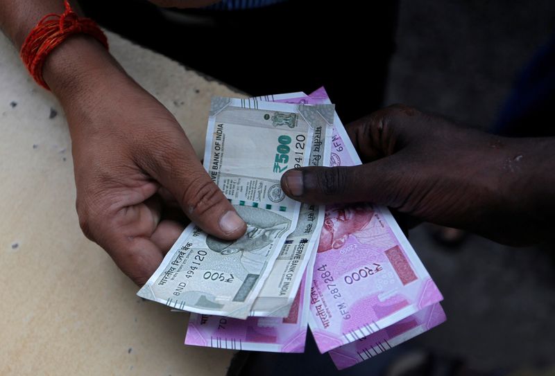 &copy; Reuters. FILE PHOTO: A customer hands Indian currency notes to an attendant at a fuel station in Mumbai, India, August 13, 2018. REUTERS/Francis Mascarenhas