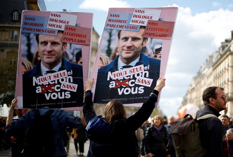 &copy; Reuters. Protesters hold placards depicting French President Emmanuel Macron during a demonstration as part of the 12th day of nationwide strikes and protests against French government's pension reform, in Paris, France, April 13, 2023.   REUTERS/Sarah Meyssonnier