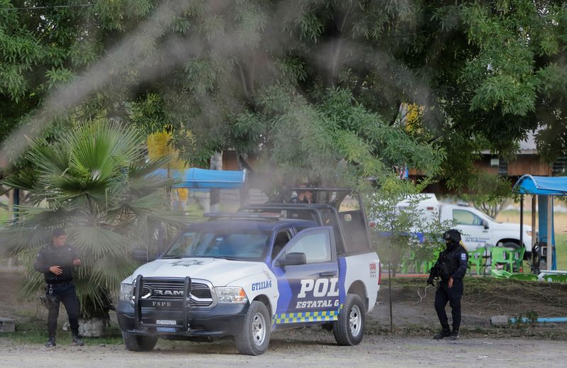 &copy; Reuters. اثنان من أفراد الشرطة يعملان في مسرح الجريمة حيث اقتحم مسلحون منتجعا في ولاية جواناخواتو بالمكسيك يوم السبت. تصوير: سيرجيو مالدونادو - رويتر