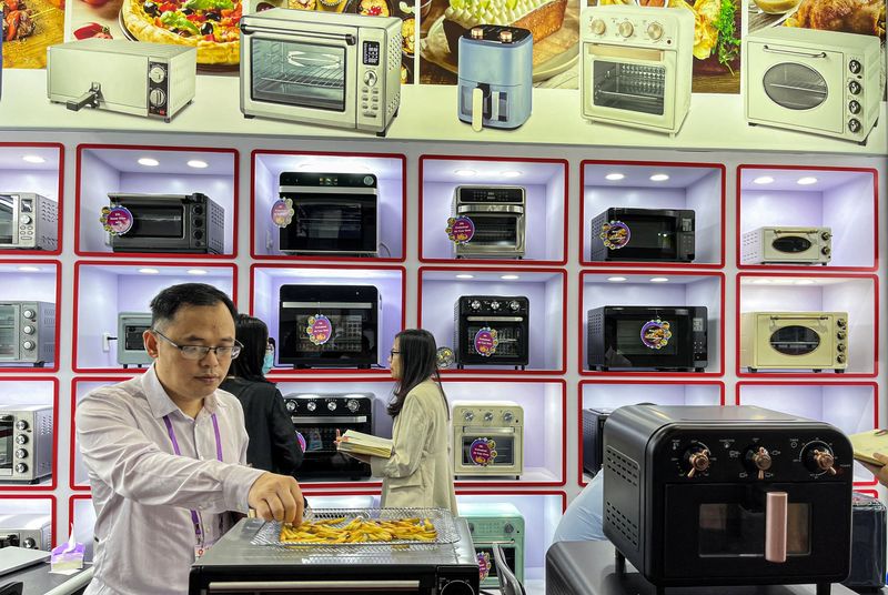 &copy; Reuters. A staff member attends to visitors at an oven retailer at the China Import and Export Fair, also known as Canton Fair, in Guangzhou, Guangdong province, China April 16, 2023. REUTERS/Ellen Zhang