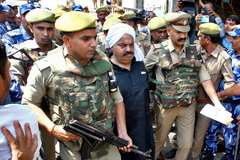 &copy; Reuters. ضباط شرطة يرافقون عتيق أحمد النائب السابق في البرلمان الهندي والمتهم في عدة قضايا جنائية أمام محكمة في براياجراج في مدينة براياجراج بالهند 