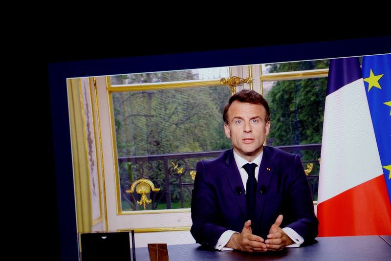 &copy; Reuters. Le président français Emmanuel Macron apparaît sur un écran, alors qu'il s'exprime lors d'un discours spécial à la nation depuis le palais de l'Élysée, après avoir signé la loi sur la réforme des retraites augmentant l'âge de départ à la ret