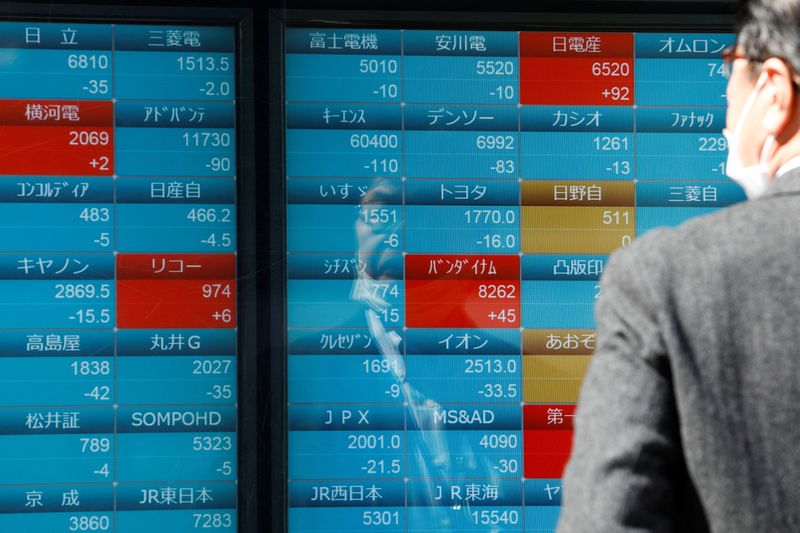 &copy; Reuters. رجل يتابع أسعار الأسهم اليابانية على لوحة إلكترونية خارج شركة للسمسرة بطوكيو في 20 مارس آذار 2023. تصوير : أندرونيكي كريستودولو - رويترز .  