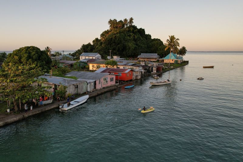 © Reuters. FILE PHOTO: The morning's first rays of sunlight hit the island community of Serua Village, Fiji, July 15, 2022. REUTERS/Loren Elliott  