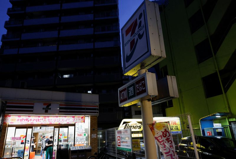 &copy; Reuters. FILE PHOTO: The signboards of a 7-Eleven store, operated by Seven & i Holdings, are partially switched off to take power-saving measures as Japanese government issues warning over possible power crunch due to heatwave in Tokyo, Japan June 29, 2022.  REUTE