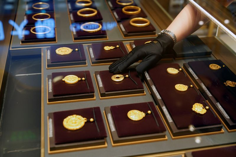 &copy; Reuters. A salesperson poses with Heritage Gold jewellery at jeweller Chow Tai Fook’s retail store in Shanghai, China August 18, 2021. Picture taken August 18, 2021. REUTERS/Aly Song/File Photo