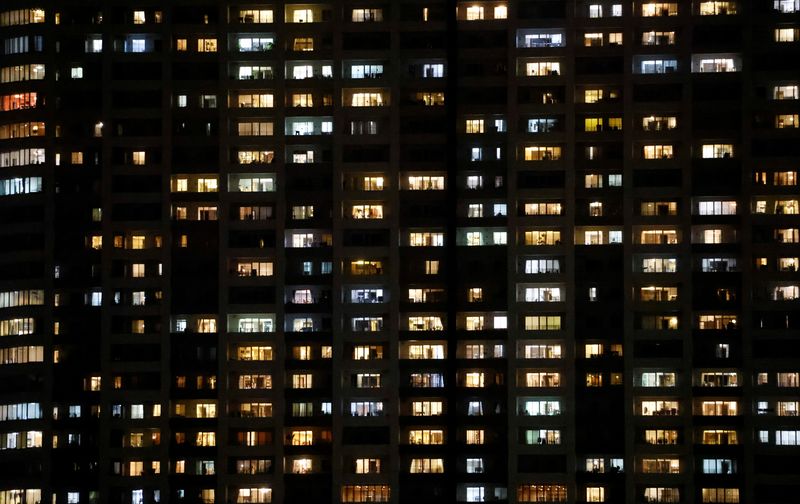 &copy; Reuters. FILE PHOTO: Illuminated apartment buildings are pictured near the IBC/MPC media center at Tokyo International Exhibition Centre (Tokyo Big Sight) for the 2020 Olympic Games that have been postponed due to the coronavirus disease (COVID-19) pandemic in Jap