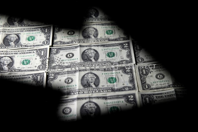 &copy; Reuters. Una serie di banconote da 1 e 2 dollari visti attraverso la silhouette di un grafico. 7 febbraio 2018. REUTERS/Dado Ruvic/Illustration/File Photo