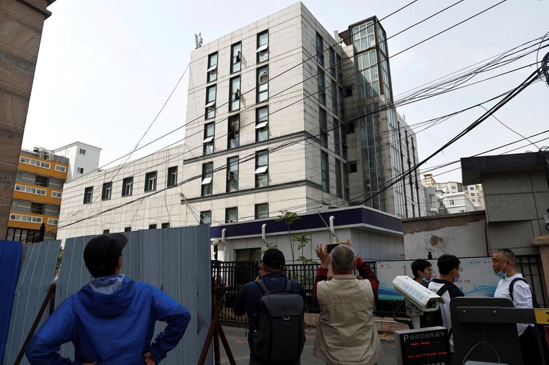 &copy; Reuters. مارة يقفون لمشاهدة مبنى مستشفى به نوافذ متضررة بعد حريق نشب في مستشفى تشانغ فنغ في بكين يوم الأربعاء. تصوير: تينجشو وانغ - رويترز