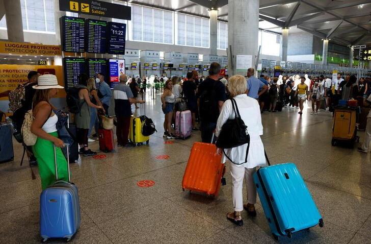 &copy; Reuters. FOTO DE ARCHIVO. Pasajeros hacen cola en los mostradores de facturación del aeropuerto de Málaga-Costa del Sol, en Málaga, España. 4 de junio de 2022. REUTERS/Jon Nazca