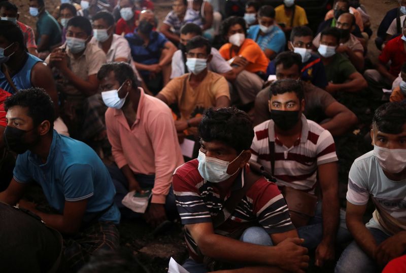 &copy; Reuters. FILE PHOTO: Migrant workers gather at the compound of their dormitory for a document check, during a joint operation by the Department of Labour and several other Malaysian government agencies on workers' living condition and other criteria of forced labo