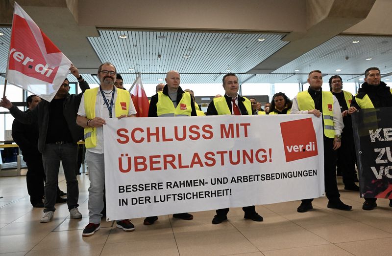 &copy; Reuters. Des travailleurs de la sécurité aérienne du syndicat allemand Verdi se rassemblent à l'aéroport de Cologne-Bonn lors d'une grève à Cologne, Allemagne, le 20 avril 2023. Sur la pancarte, on peut lire "mettre fin à la pression du travail". REUTERS/J
