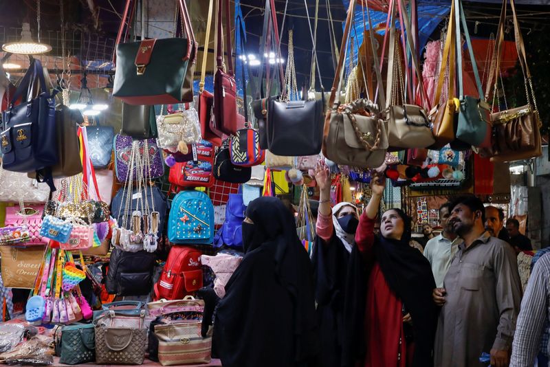 &copy; Reuters. People look at handbags on display outside shops in a market, ahead of Eid al-Fitr celebrations in Karachi, Pakistan April 19, 2023. REUTERS/Akhtar Soomro