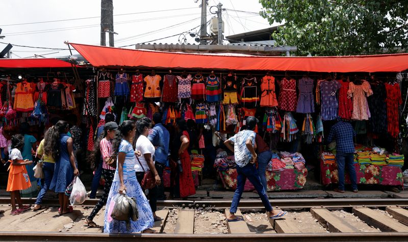 &copy; Reuters. FILE PHOTO: People gather around a readymade clothing stall on the side of a railway track ahead of the Sinhala and Tamil New Year festival, in Colombo, Sri Lanka April 11, 2023. REUTERS/Dinuka Liyanawatte