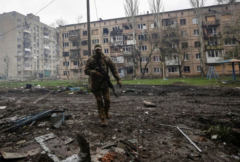 &copy; Reuters. 　４月２３日、ロシア国防省は、ウクライナ東部ドネツク州の要衝バフムトでロシア軍が前進したと表明した。写真はバフムトを歩くウクライナ軍の兵士。２１日撮影（２０２３年　ロイタ