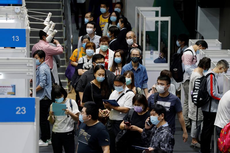 &copy; Reuters. FILE PHOTO: Job seekers wearing face masks fill in forms at the Wan Chai Job Fair, following the coronavirus disease (COVID-19) outbreak, in Hong Kong, China October 29, 2020. REUTERS/Tyrone Siu