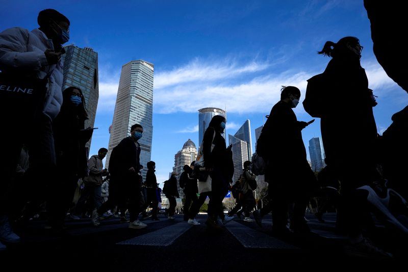 &copy; Reuters. FILE PHOTO: People cross a street near office towers in the Lujiazui financial district, ahead of the National People's Congress (NPC), in Shanghai, China, February 28, 2023. REUTERS/Aly Song