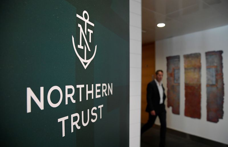 &copy; Reuters. FILE PHOTO: An employee walks past a company logo at Northern Trust offices in London, Britain August 1, 2019. Picture taken August 1, 2019. REUTERS/Toby Melville