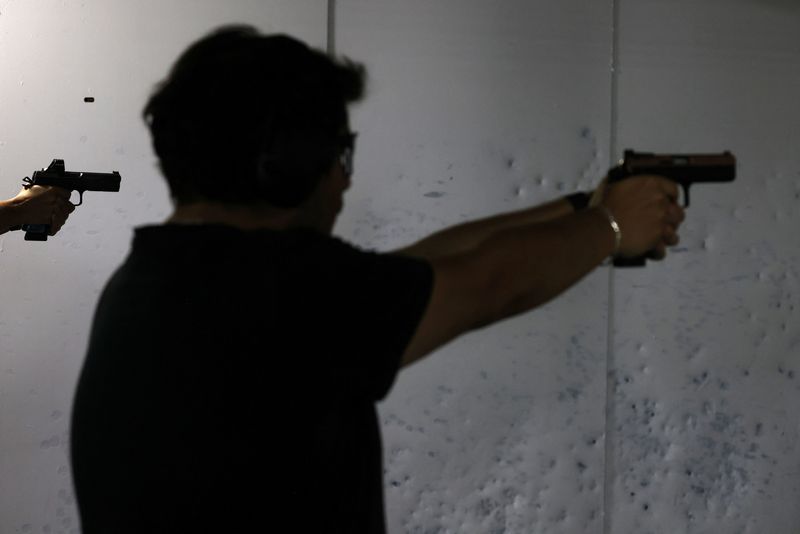 &copy; Reuters. Residentes locales aprenden a usar y disparar un arma durante una sesión de entrenamiento dentro del club de tiro 'La Reina' en Santiago, Chile, 5 de abril de 2023. REUTERS/Ivan Alvarado